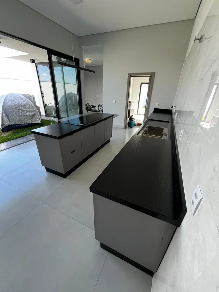 Cozinha com ilha e bancada longa: a foto da obra tirada no celular, no dia da entrega